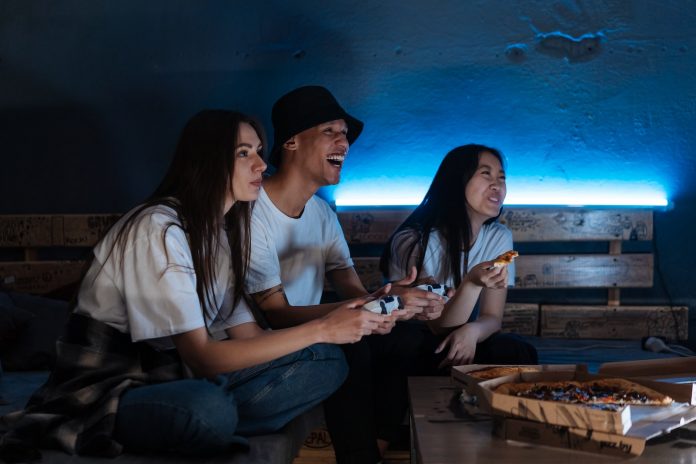 People Playing Video Games while Eating Pizza